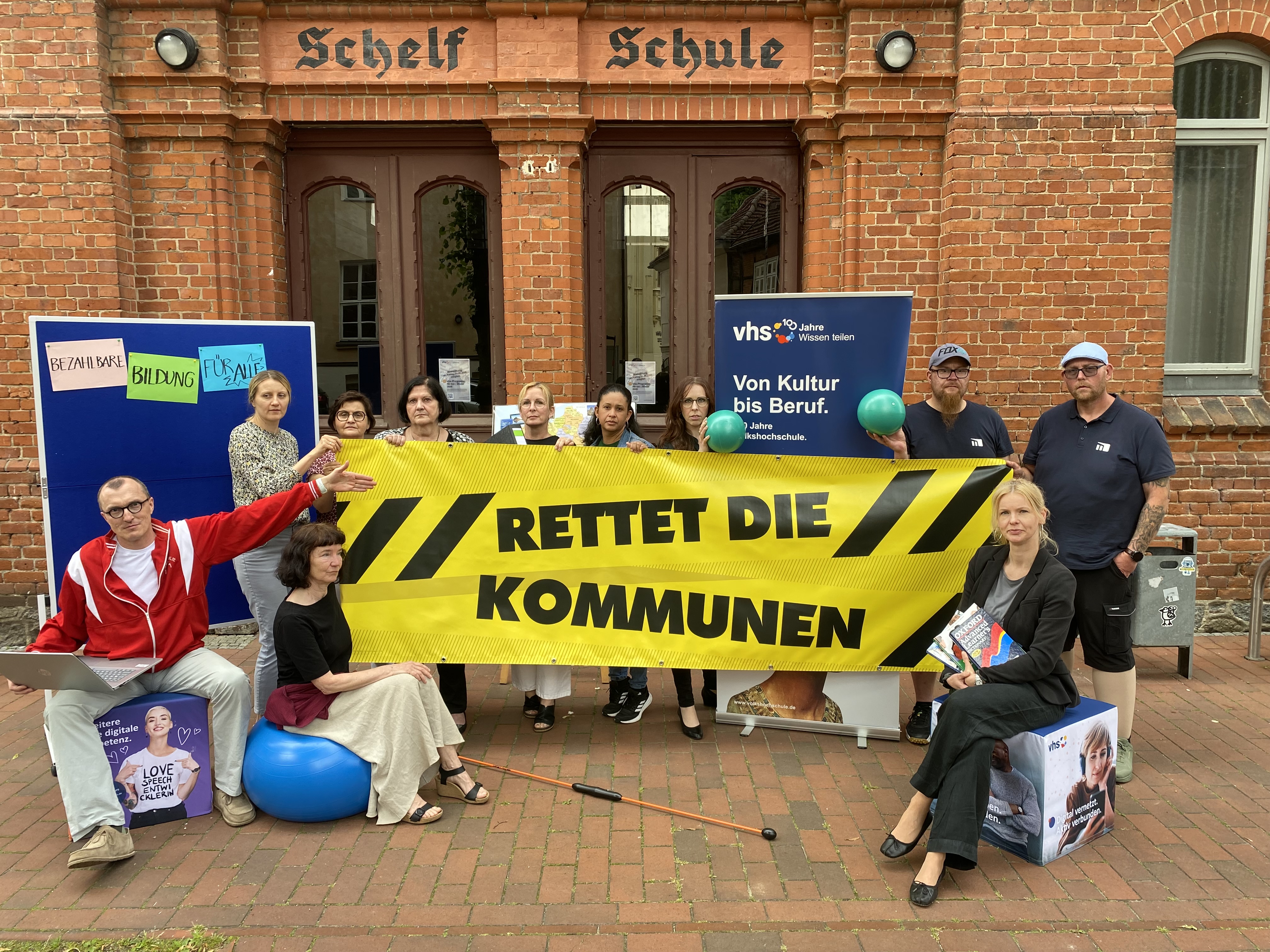 Team der vhs Schwerin mit Banner "Rettet die Kommunen"